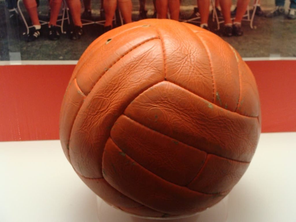 A worn orange-brown leather football from the 1966 World Cup final on display.