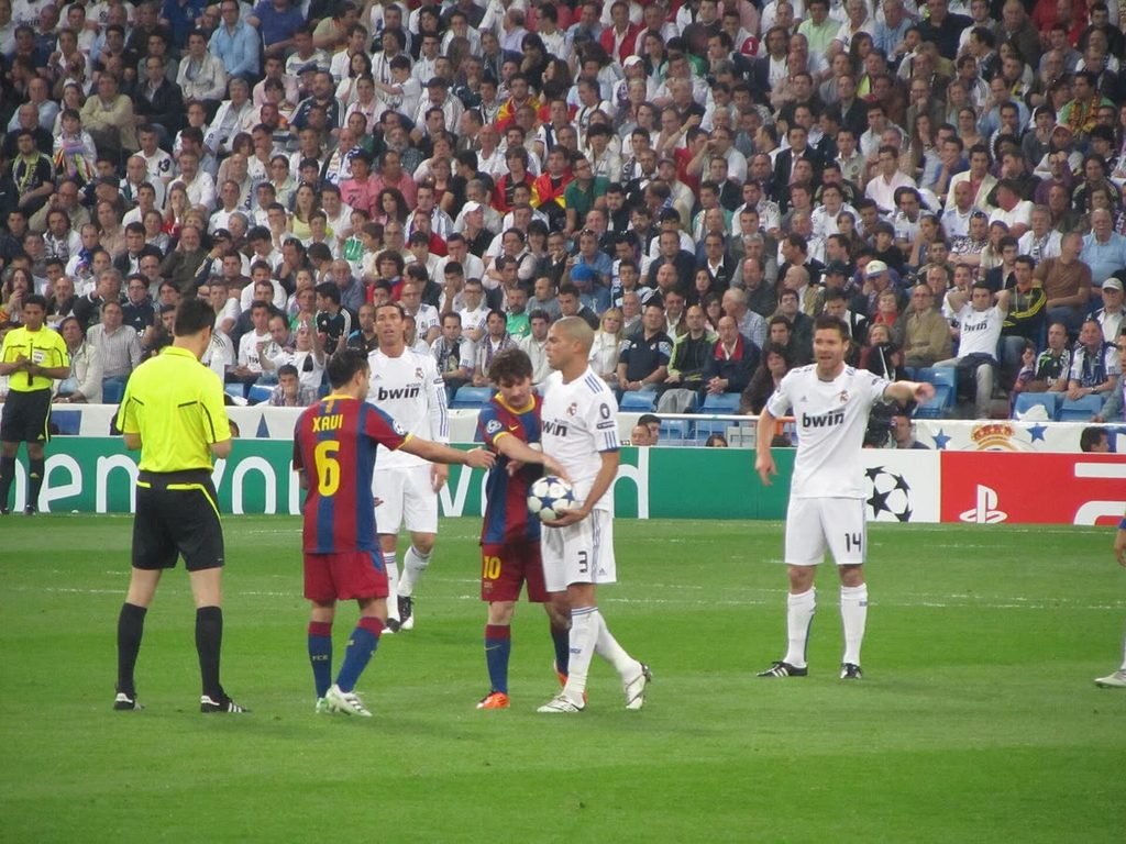 Barcelona and Real Madrid players including Xavi, Messi and Pepe on the pitch at the Bernabéu in 2011.
